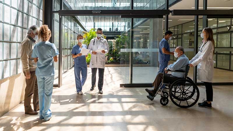 A group of people in scrubs and face masks in a hallway